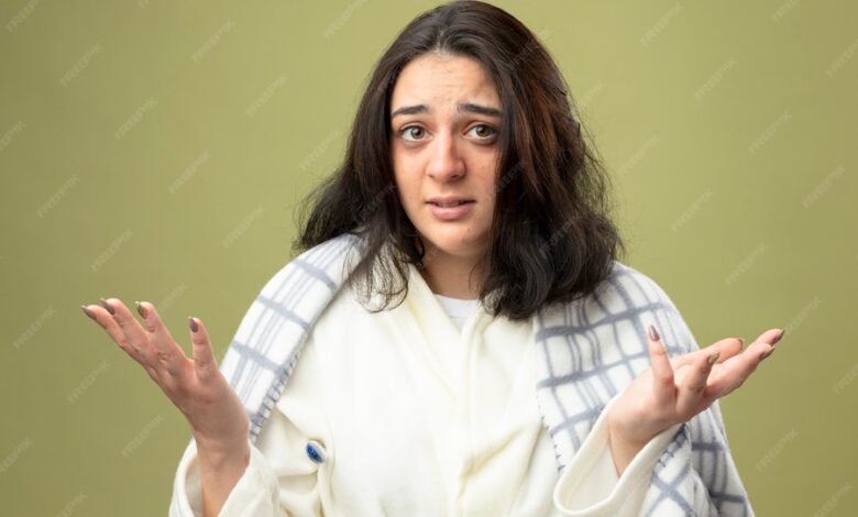 clueless young caucasian ill girl wearing robe wrapped plaid looking camera showing empty hands with thermometer underarm isolated olive green background 141793 75151