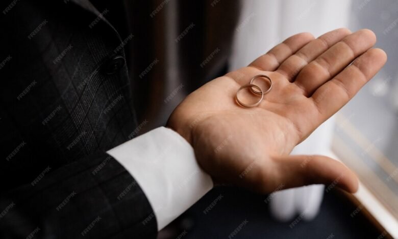 groom holds his palm two wedding rings 8353 10241