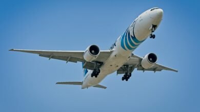 EgyptAir Boeing 777 flying against the clear blue sky over New York City.